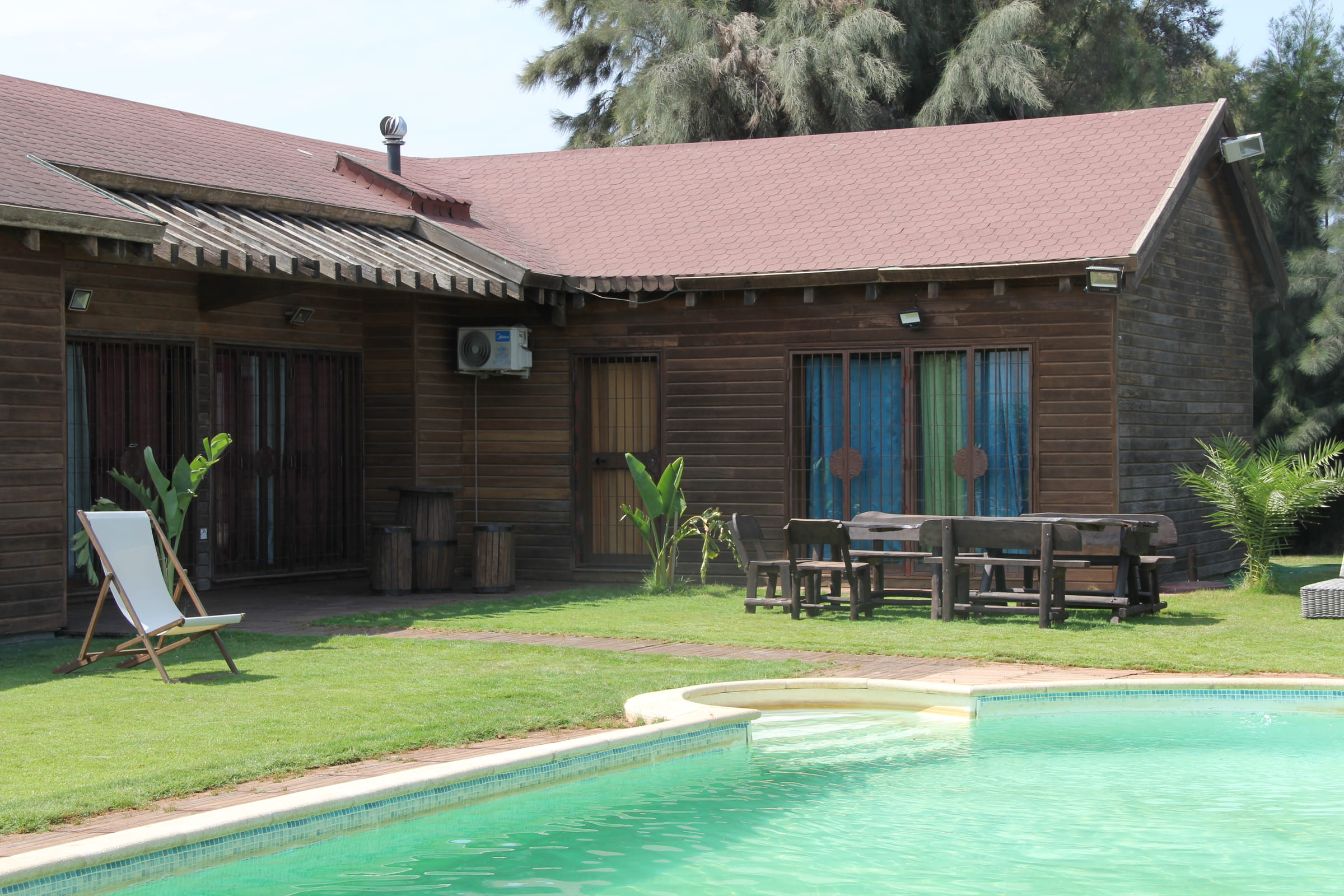 Façade en bois du Chalet Essanya avec sa terrasse ouverte sur la piscine