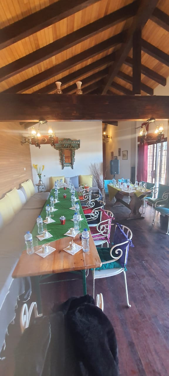 Salle de table d’hôte dressée pour un repas de groupe, décor arabesque